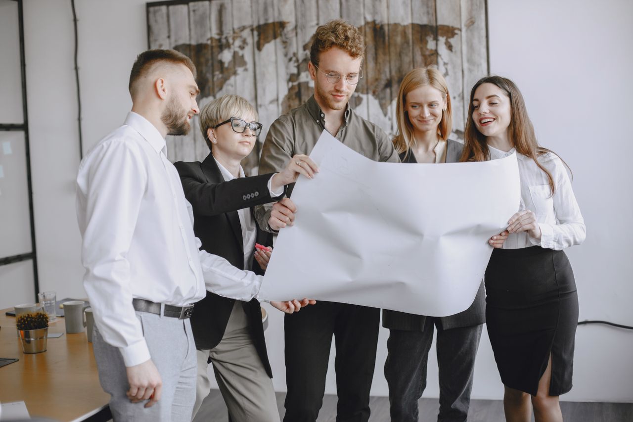 The Art of Drawing Readers In: Your attractive post title goes here Group of professionals in an office setting analyzing project plans together.